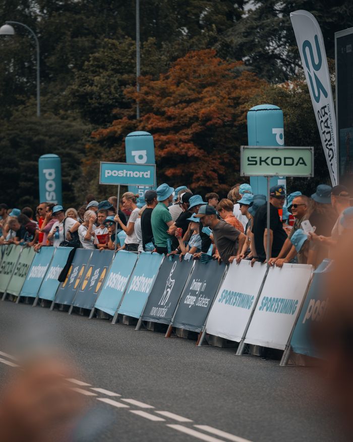 A crowd of spectators eagerly watching a cycling competition outdoors.