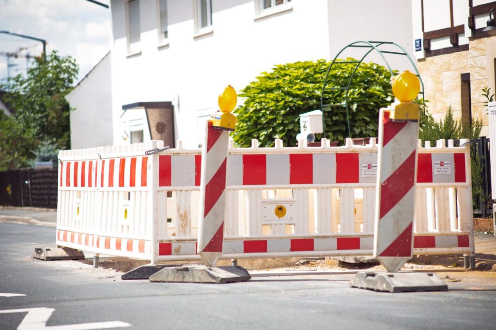 Bright road barrier with striped pattern signals construction on suburban street.
