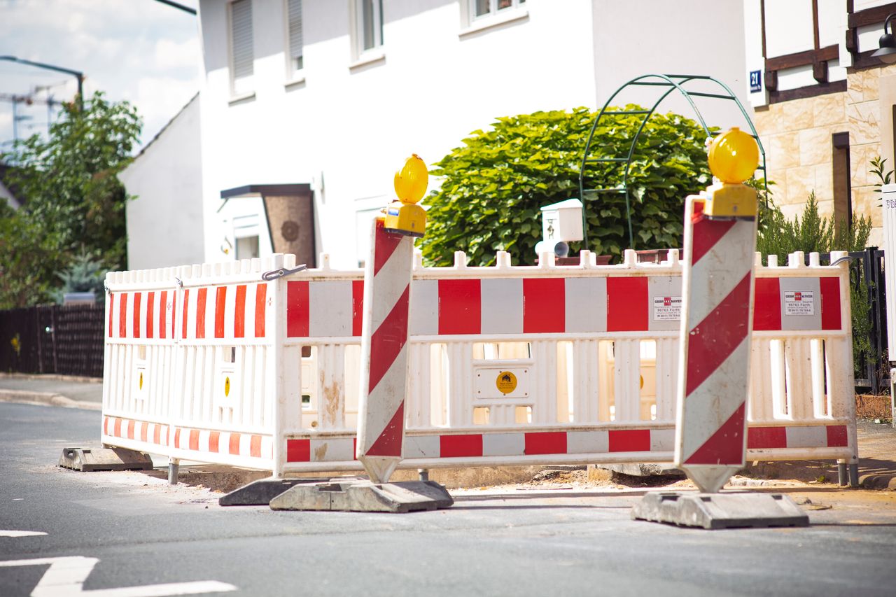 Bright road barrier with striped pattern signals construction on suburban street.