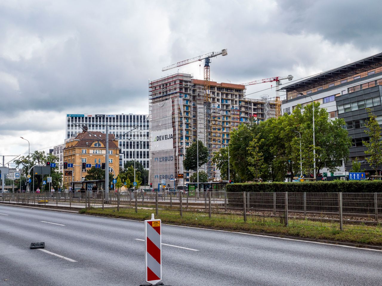 Crafting Captivating Headlines: Your awesome post title goes here Busy cityscape with construction cranes and high-rise buildings under cloudy skies.